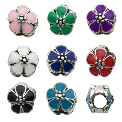 Antique silver bead and flower charms arranged on a light background
