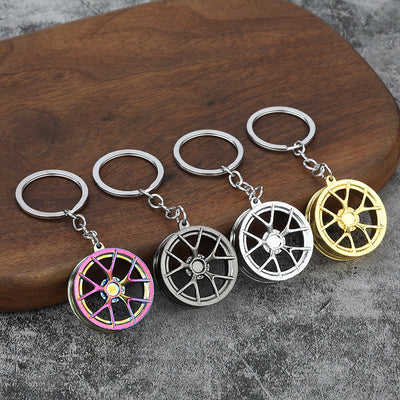 Four wheel-rim keychains in assorted metallic finishes