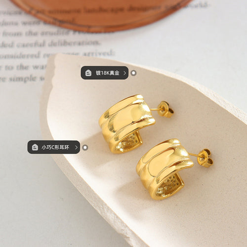 Gold C-shape ribbed stud hoops on ceramic dish with feature tags