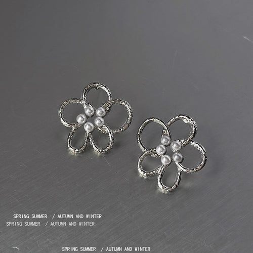 Silver-tone open-five-petal pearl-center studs in the first product display.