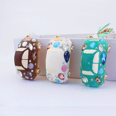 Green, white, and brown car pendants stand upright with multicolor decorative accents.