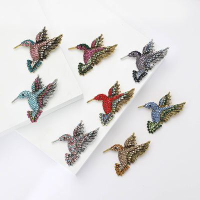 Product display showing a flying hummingbird covered in rows of colored crystals