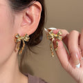 Gold Tone Sculptural Bow Ribbon Long Stud Earrings view 1