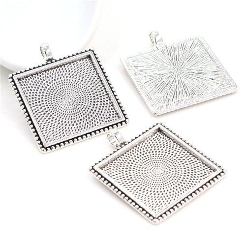 Grouped detail view of square pendant trays with radiating geometric textures on the reverse