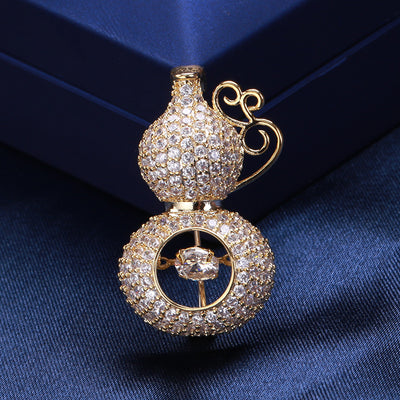 Front view of pave crystal gourd brooch with scroll handle and floating center stone against a white background.