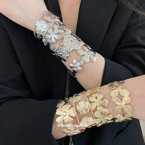 Gold and silver flower open cuff bangles stacked on both wrists