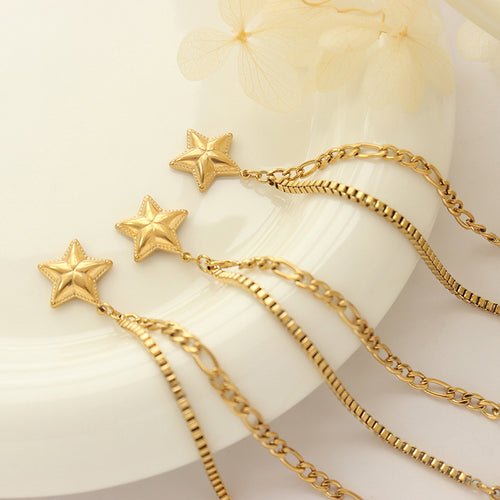 Three gold star dual-chain bracelets flat lay on white plate flowers