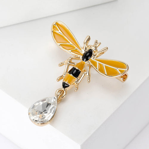 Gold yellow wing bee brooch angled on white geometric block