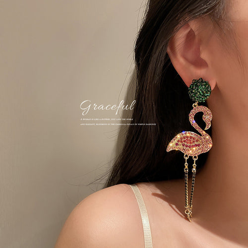 Styled or close-up view 2 of flamingo crystal tassel earrings in pink and green
