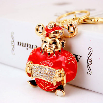 Angled front view of the red Wealth God charm with gold-tone details and clear stones.