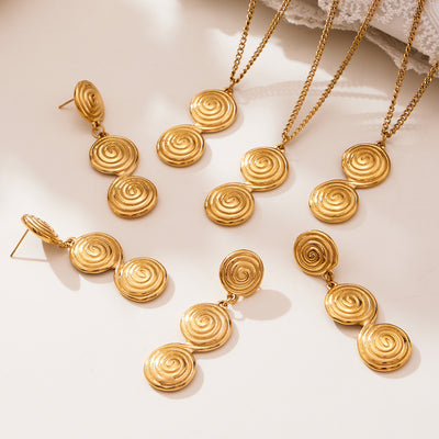 Coordinated set view of spiral disc pendant necklace and drop earrings in main image 1.