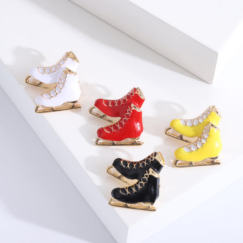 Four enamel ice skate brooches white black red yellow gold blades
