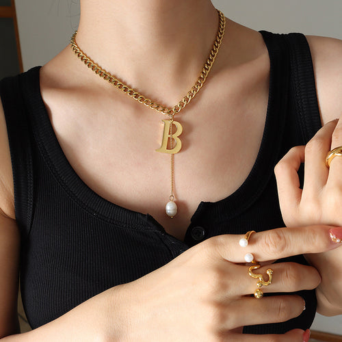 Gold letter B cuban chain pearl drop necklace worn on black top