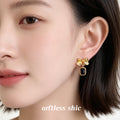 Gold Tone Textured Bow And Black Rectangular Stone Drop Earrings view 2