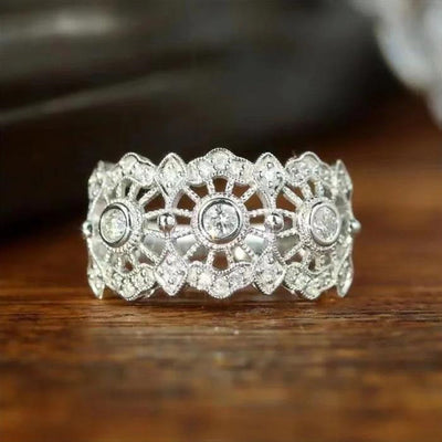 Silver filigree openwork CZ wide band ring front view on wood