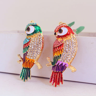 Two gold-tone parrot charms with blue-green and red-pink multicolor details.