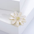 White Acrylic Daisy Brooch With Polished Metal And Sculpted Decorative Details view 2