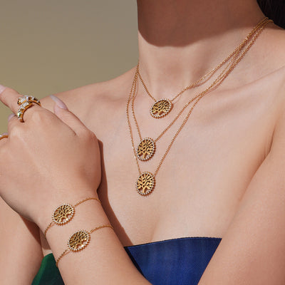 Coordinated set view of crystal rimmed tree of life necklace and bracelet in main image 1.