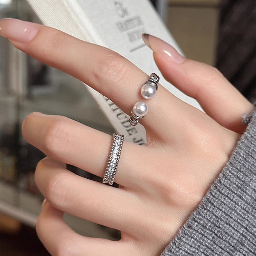 Double pearl and pave silver open rings worn on fingers