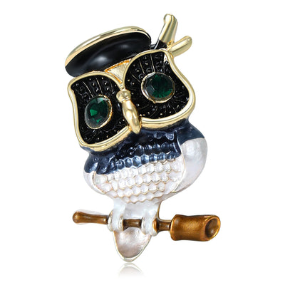 Black Owl, Pink Owl brooch styles arranged on a light display