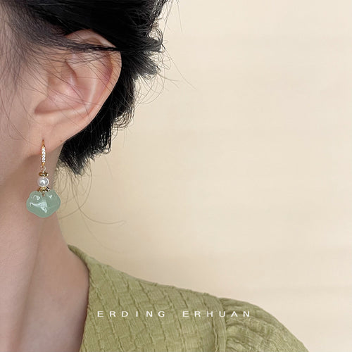 Green longevity lock drop earring worn on ear side profile