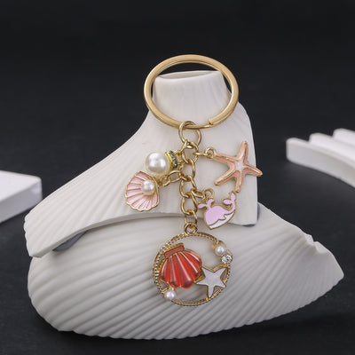 Overview showing the available color and design variations of the pink and blue ocean pearl-look metal keychain