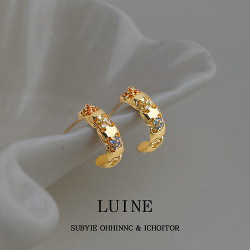 Gold-tone multicolor-stone chunky huggie hoops in the first product display.