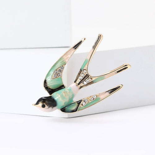 Front view of flying swallow enamel brooch with crystal wing details