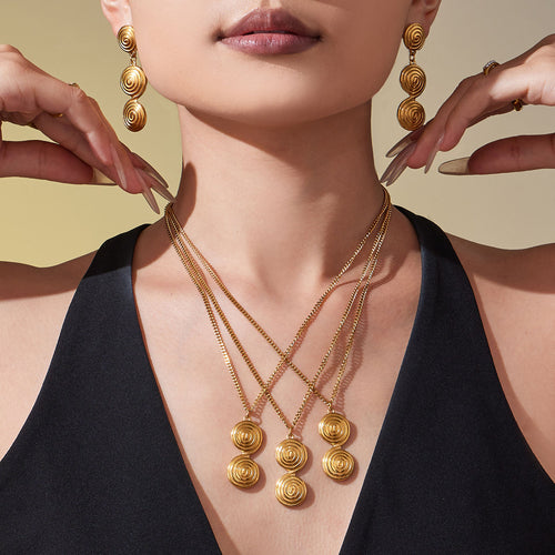 Coordinated set view of spiral disc pendant necklace and drop earrings in main image 2.