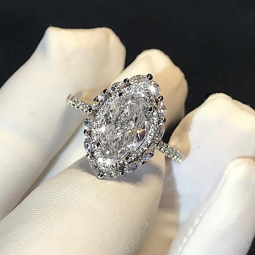 Marquise halo crystal ring on white-gloved fingers