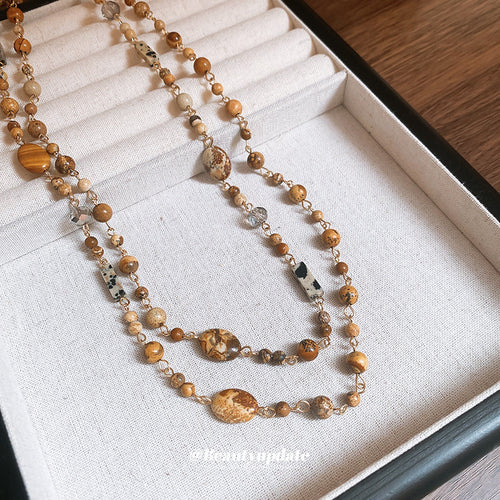 Mixed brown geometric bead necklace on white jewelry tray