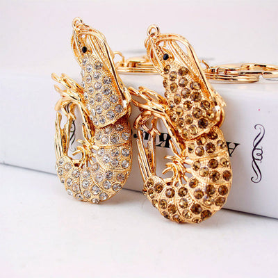 Clear and light brown rhinestone lobster keychains displayed side by side.