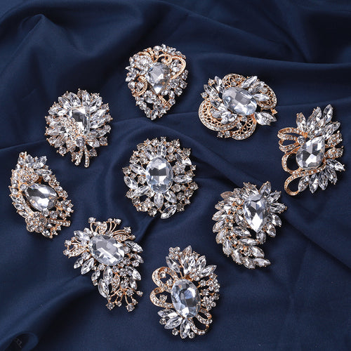 The second image presents an alternate display of the assorted clear crystal brooches.