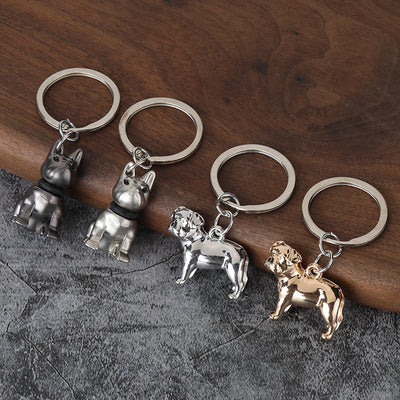Four sitting and standing dog keychains in metal finishes