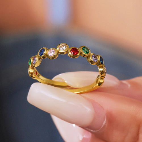 Close-up gold multicolor bezel zircon open ring held between fingers