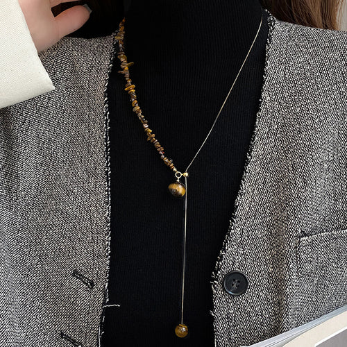 Product image 1 showing a small brown oval bead and slim drop on a silver tone chain