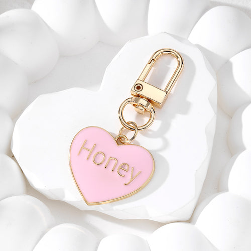 Close-up showing the colors and surface details of gold Tone Honey Heart and Round Clip Keychains in Eight Colors
