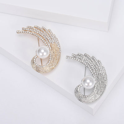 Gold Feather, Silver Feather brooch styles arranged on a light display