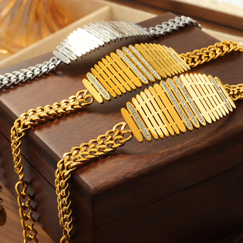 Gold and steel lattice plaque bracelets on wood jewelry box