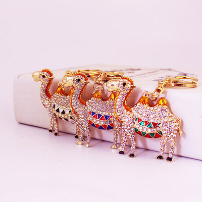 Several gold-tone camel keychains display black, blue, red, and green saddle accents.