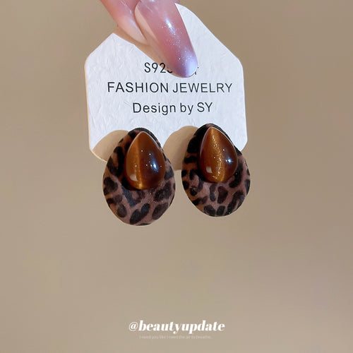 brown leopard print teardrop stud earrings with cabochons shown in an on-ear styling view