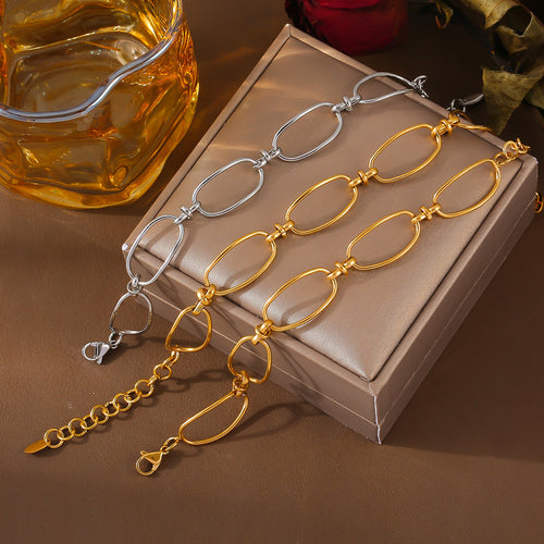 Gold and steel oval link bracelets on beige jewelry box