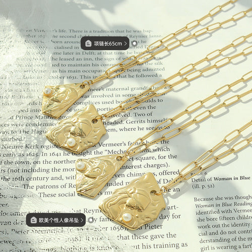 Four gold portrait pendants with pearl accents on book pages