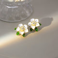 White Enamel Camellia Flower Stud Earrings Green Leaves view 1