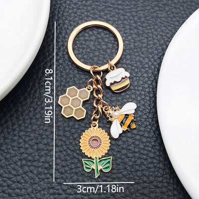 Front product photo of yellow sunflower beehive honey jar and bee charm keychain showing the pictured design arrangement