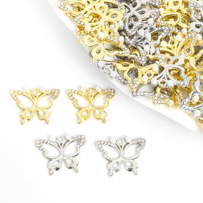 Assorted pearl body crystal butterfly charms arranged beside a tray on white