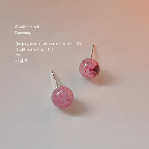 Pink speckled ball studs with silver posts on pale surface