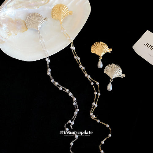Four shell duckbill clips pearl drop and chain styles on black velvet