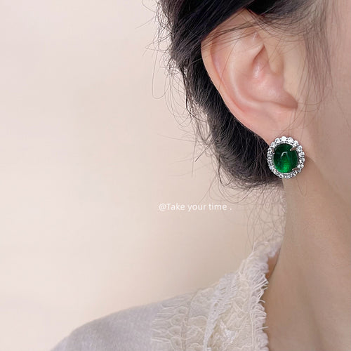Silver green cabochon halo stud earring worn on ear side profile
