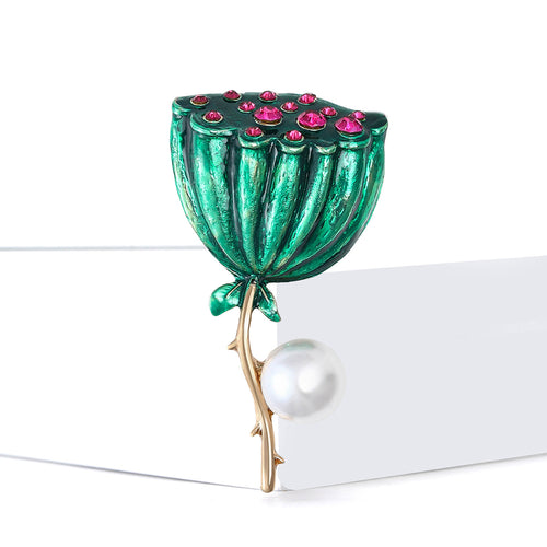 Green lotus pod brooch angled on white block with gold stem